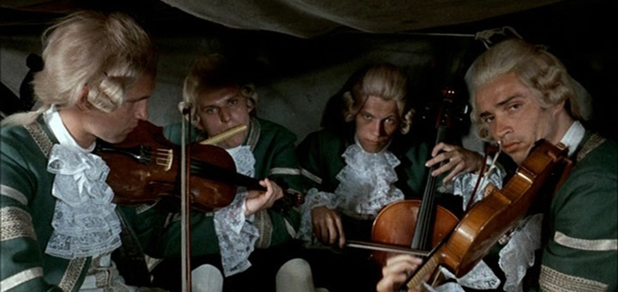 4 violinists play in the back of a carriage in a still from 'Pacho, the Thief of Hybe' (1976)