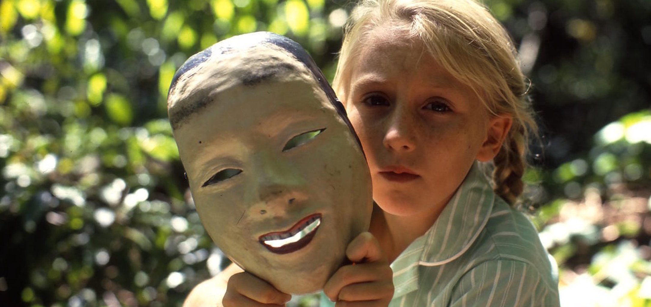 Rebecca Smart as Celia holding a mask in a still from Celia (1989)