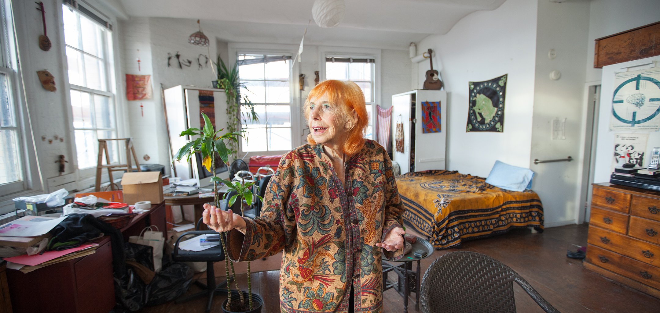 Edith wearing a colourful dress standing in her studio in a still from Winter at Westbeth (2016)