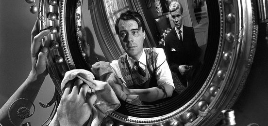 Hugo polishes a mirror with Tony looking on - Dirk Bogarde and James Fox in The Servant (1963)