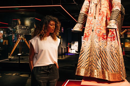 A woman looking at a costume from The Last Emperor in the Moving Pictures section of The Story of the Moving Image