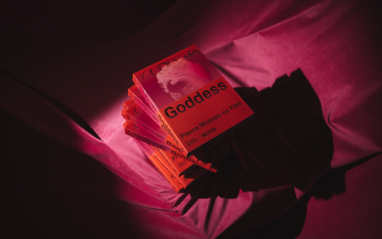 A stack of books titled 'Goddess'. The image is dark and the books are stacked on a red, velvety cloth