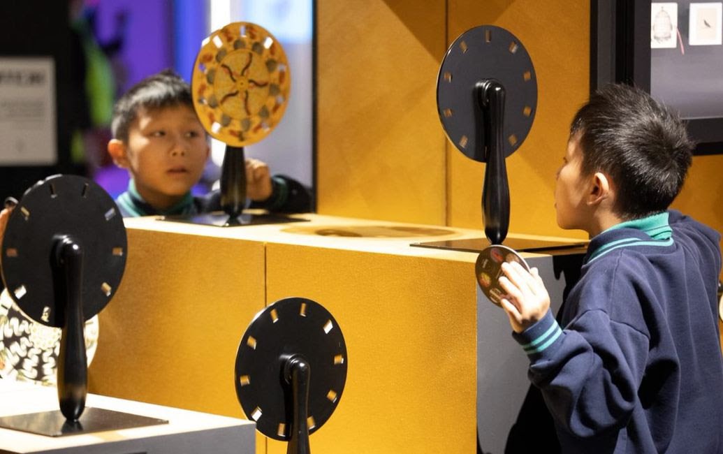 A student using early moving image devices in The Story of the Moving Image exhibition