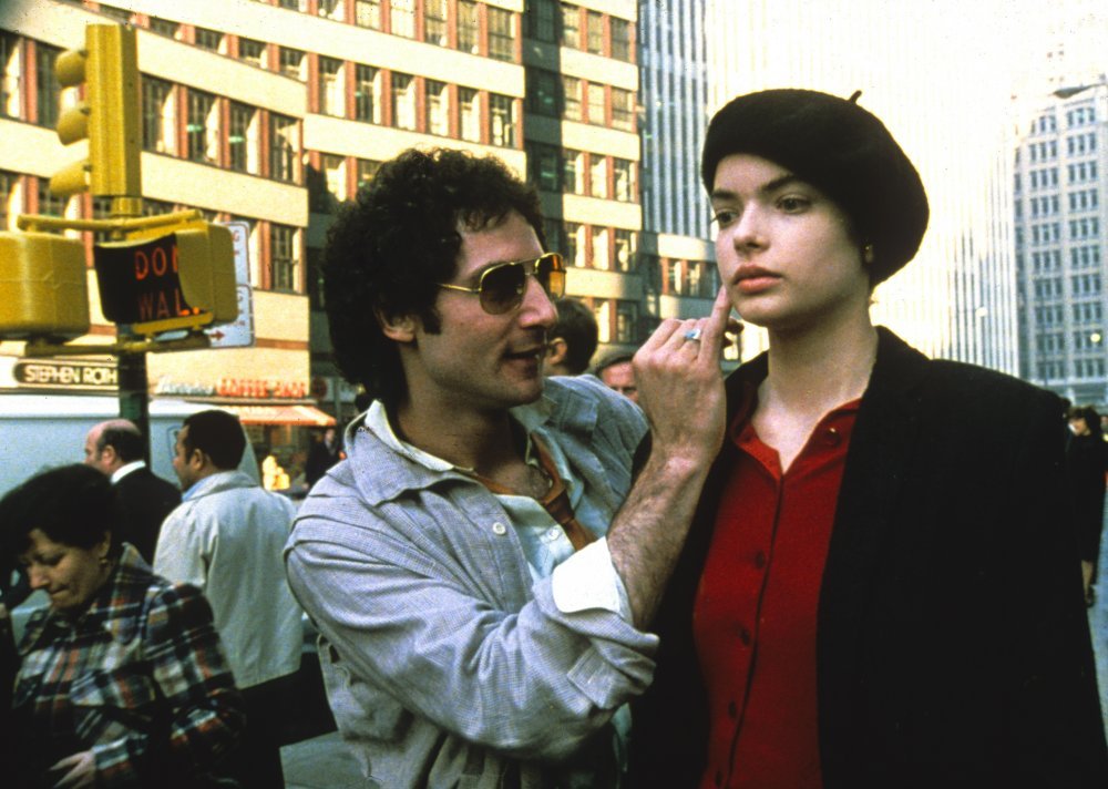 An image of a beautiful young woman played by Zoe Lund, wearing a red top and black beret, with red lipstick, being harrassed in a new york street by a photographer played by Abel Ferrera.