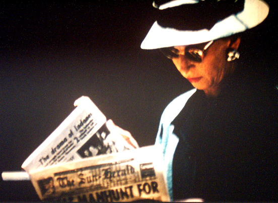 Woman reading a newspaper - a still from Sunday in Melbourne by Gil Brealey