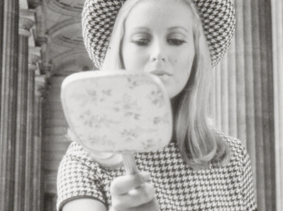 A model looks into a hand mirror - still from Wool Fashion Awards 1967